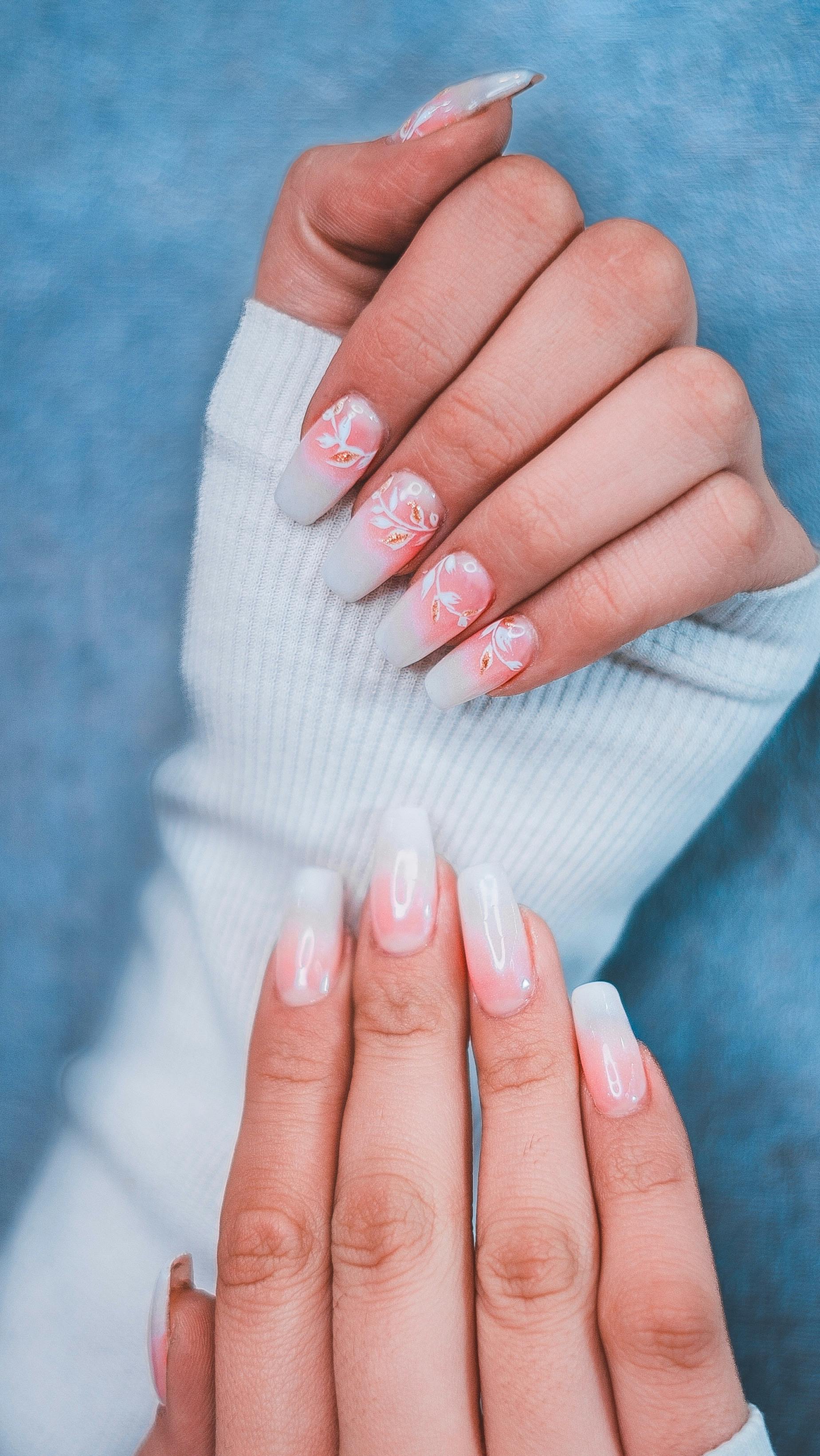 Hands with soft gradient manicure and floral accents