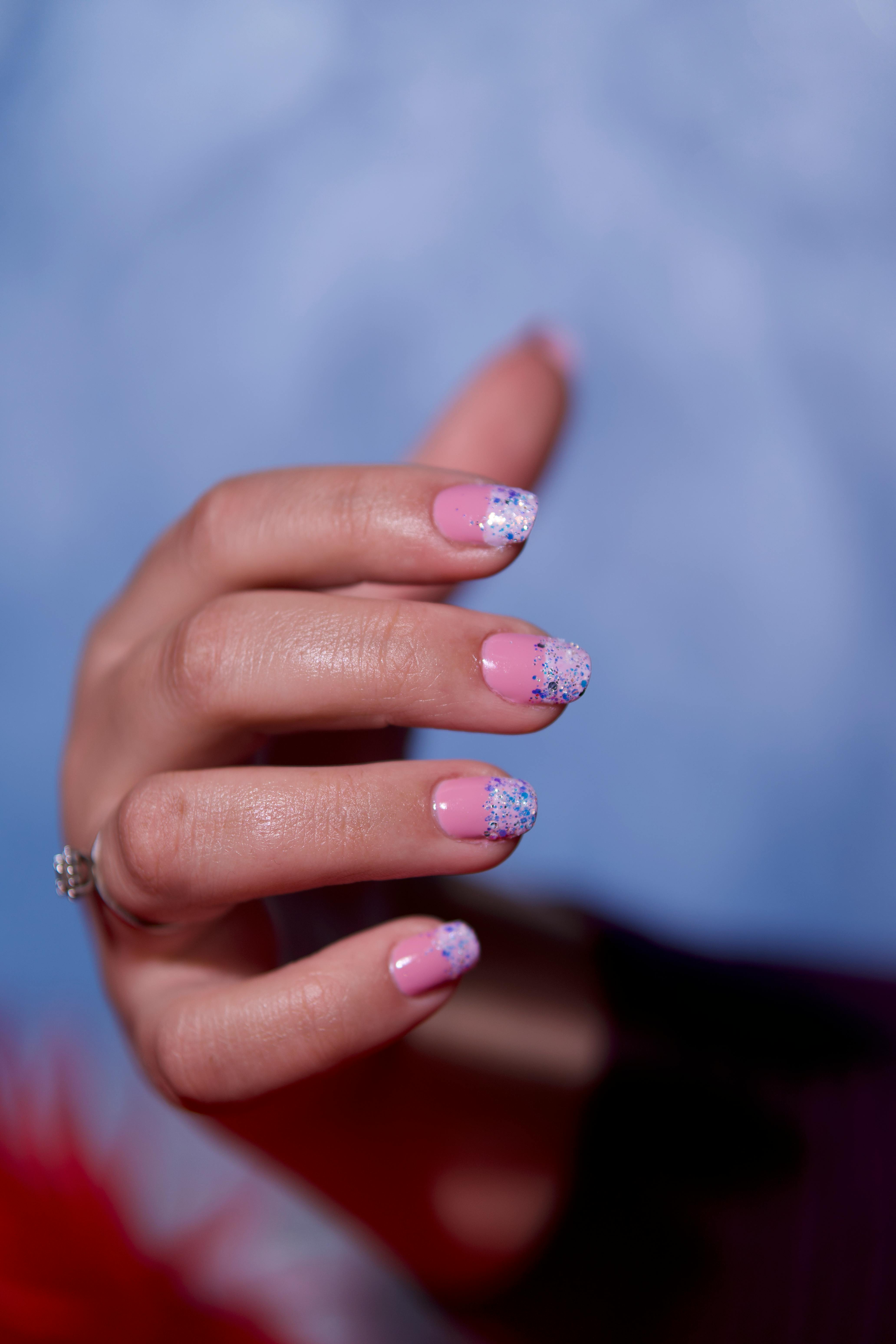 Hand with pink and blue floral nail art